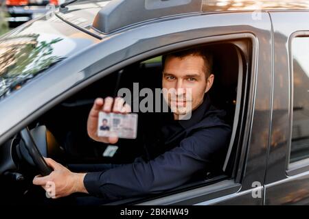 Un homme montre un permis de conduire à un policier. Homme d'affaires regardant la caméra Banque D'Images