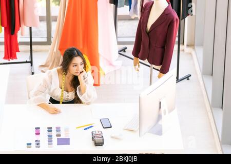 Vue de dessus du dessin de jeune designer de mode asiatique adulte et esquisse son travail à la maison comme atelier studio avec palette de couleurs. Utilisation pour entrepreneur sm Banque D'Images