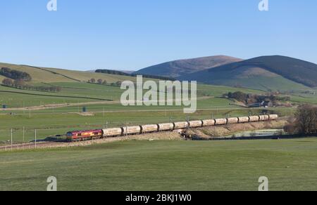 DB CARGO / EWS classe 66 locomotive passant par Wandell (nord d'Abington, sud de l'Écosse) sur la côte ouest avec un train de fret de citernes de ciment Banque D'Images