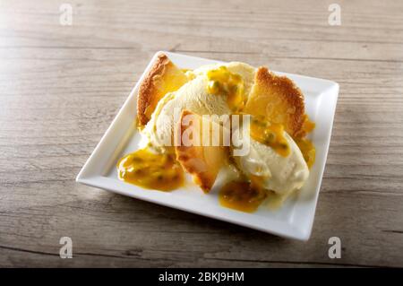 Glace à la vanille aux amandes et coulis de fruits de la passion Banque D'Images