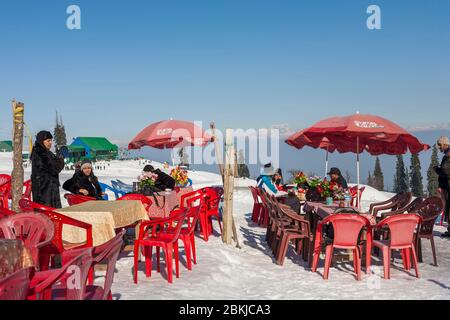 Inde, Jammu-et-Cachemire, Gulmarg, touristes indiens assis dans un restaurant en plein air sur la neige, à Kongdoori, première station du téléphérique de Gondola, altitude 3090 mètres Banque D'Images