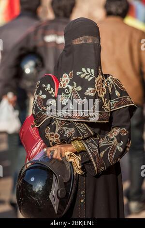 Inde, Rajasthan, Jodhpur, jeune femme masquée par un voile islamique noir et portant un casque de moto Banque D'Images