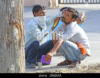 Beawar, Inde. 3 mai 2020. un barbier qui s'est posé sur le bord de la route ravive un client au cours du gouvernement a imposé un verrouillage national à la suite de la nouvelle pandémie de coronavirus (COVID-19) à Beawar. (Photo de Sumit Saraswat/Pacific Press/Sipa USA) crédit: SIPA USA/Alay Live News Banque D'Images