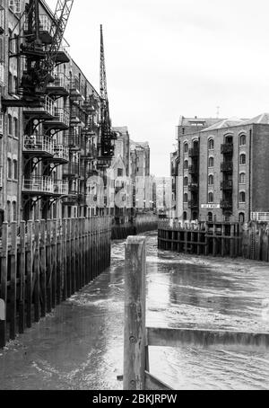 Immeubles d'appartements au-dessus du lit de rivière boueux Banque D'Images