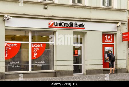 PRAGUE, RÉPUBLIQUE TCHÈQUE - JUILLET 2018 : extérieur d'une succursale de la UniCredit Bank à Prague. Une personne retire de l'argent d'un distributeur automatique de billets. Banque D'Images