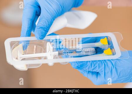 Déballage d'une seringue d'injection pour un soulèvement. Seringue dans les mains d'un médecin de près. Cosmétologie d'injection. Banque D'Images