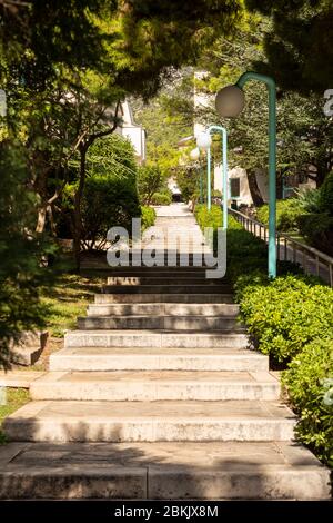 Bol, Croatie, le 10 septembre 2019. De longs escaliers avec arbres et verdure près du boulevard sur l'île de Brac en Dalmatie. Lanternes modernes à côté du chemin Banque D'Images