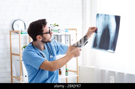 Jeune vétérinaire chirurgien examinant la radiographie à l'hôpital animal Banque D'Images