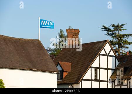 Un drapeau soutenant le NHS volant au-dessus d'une maison de campagne à Claverdon, Warwickshire, Royaume-Uni. Banque D'Images