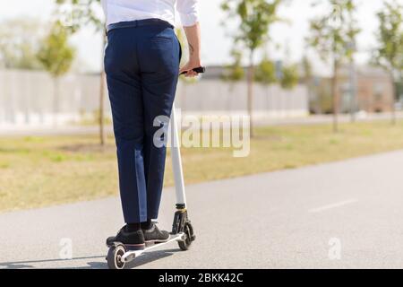 Young businessman riding scooter électrique à l'extérieur Banque D'Images