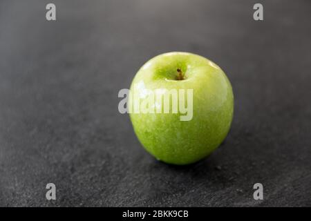 pomme verte mûre sur fond de pierre d'ardoise Banque D'Images