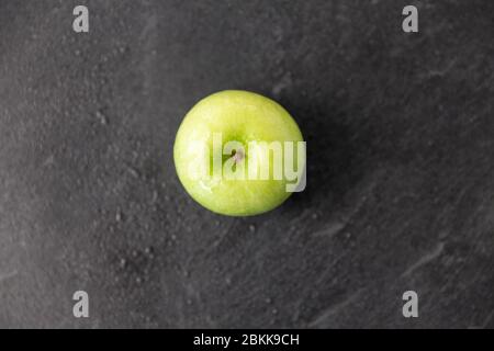 pomme verte mûre sur fond de pierre d'ardoise Banque D'Images