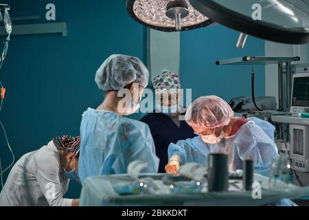 Groupe des chirurgiens en salle d'opération. L'équipe médicale d'effectuer la chirurgie en salle d'opération. Banque D'Images