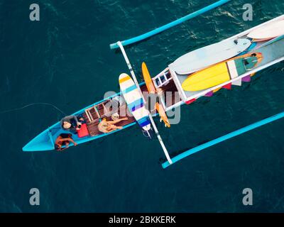 Vue aérienne des surfeurs et du bateau dans l'océan, Lombok, Indonésie Banque D'Images