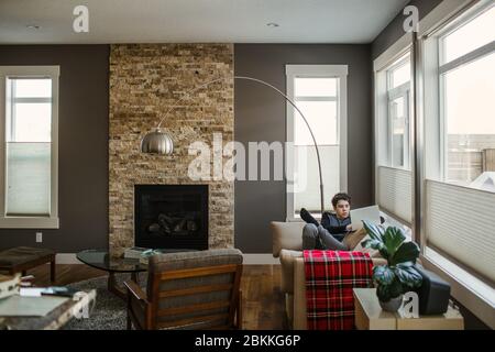 Un garçon sur un ordinateur portable à la maison pendant l'isolement Banque D'Images