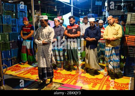 Les travailleurs d'un marché de gros sont vus à l'intérieur de la mosquée tout en priant pendant le mois Saint du Ramadan. Ramadan est le mois holistique du calendrier islamique où les dévots sont à jeun de l'aube jusqu'au crépuscule. Les musulmans du monde entier célèbrent le mois du Ramadan et ont trouvé diverses façons de célébrer ce mois du Ramadan, car les restrictions imposées par les pays pour freiner la propagation du Coronavirus ont fermé des mosquées pour empêcher les rassemblements. Banque D'Images