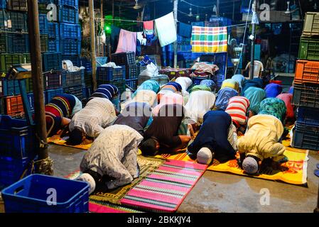 Les travailleurs d'un marché de gros sont vus à l'intérieur de la mosquée tout en priant pendant le mois Saint du Ramadan. Ramadan est le mois holistique du calendrier islamique où les dévots sont à jeun de l'aube jusqu'au crépuscule. Les musulmans du monde entier célèbrent le mois du Ramadan et ont trouvé diverses façons de célébrer ce mois du Ramadan, car les restrictions imposées par les pays pour freiner la propagation du Coronavirus ont fermé des mosquées pour empêcher les rassemblements. Banque D'Images