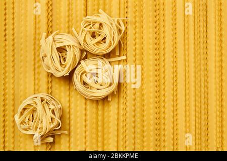 tagliatelle de pâtes sèches et fond doré de mafaldini Banque D'Images
