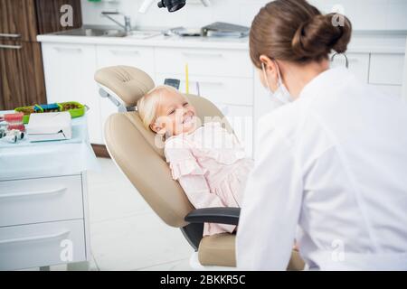 Le médecin traitant les dents de petit enfant dans la clinique dentaire. Banque D'Images