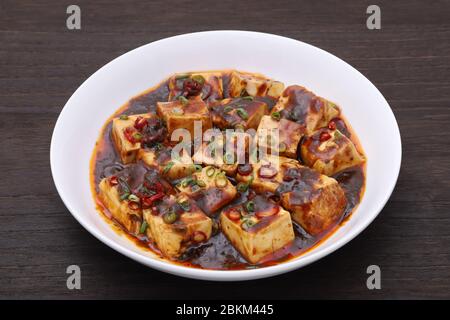 Cuisine chinoise mapo doufu dans un plat sur une table en bois Banque D'Images