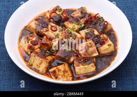 Cuisine chinoise mapo doufu dans un plat sur une table en bois Banque D'Images