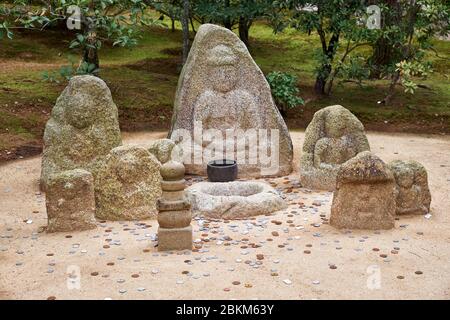 La vue des images et des pièces bouddhistes de Jizo que les visiteurs ont jeté dans le parc du temple Kinkaku-ji. Kyoto. Japon Banque D'Images