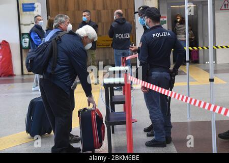 Bologne, Italie. 4 mai 2020. Les policiers vérifient les passagers à la gare centrale de Bologne à Bologne, en Italie, le 4 mai 2020. La pandémie de coronavirus a coûté la vie à plus de 29 000 personnes en Italie, portant le nombre total d'infections, de morts et de reprises à 211 938 lundi, selon les dernières données publiées par le Département de la protection civile du pays. Les Italiens ont plus de libertés lundi, car certaines restrictions sur les activités productives et les mouvements personnels ont été assouplies pour la première fois après presque huit semaines. Crédit: Gianni Schicchi/Xinhua/Alay Live News Banque D'Images