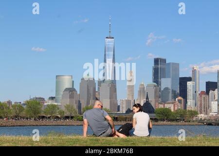 3 mai 2020, Jersey City, New Jersey, États-Unis: Ce couple ne porte pas de masque installé au Liberty State Park le long de la rivière Hudson à Jersey City, en face du World Trade Center. C'est l'un des sites extérieurs avec les clubs de golf du New Jersey rouverts au cours du week-end malgré une semaine sombre qui a vu le nombre de morts quotidiennes dépasser le péage de l'État de New York avant de descendre. ''la réouverture est un test énorme, '' a prévenu Gov. Phil Murphy disant que « si les choses vont mal », il peut fermer à nouveau les parcs et les terrains de golf. Les visiteurs doivent adhérer à l'éloignement social et les revêtements de visage sont fortement encouragés. L'état Banque D'Images