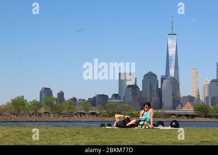 3 mai 2020, Jersey City, New Jersey, États-Unis: Ce couple ne porte pas de masque installé au Liberty State Park le long de la rivière Hudson à Jersey City, en face du World Trade Center. C'est l'un des sites extérieurs avec les clubs de golf du New Jersey rouverts au cours du week-end malgré une semaine sombre qui a vu le nombre de morts quotidiennes dépasser le péage de l'État de New York avant de descendre. ''la réouverture est un test énorme, '' a prévenu Gov. Phil Murphy disant que « si les choses vont mal », il peut fermer à nouveau les parcs et les terrains de golf. Les visiteurs doivent adhérer à l'éloignement social et les revêtements de visage sont fortement encouragés. L'état Banque D'Images