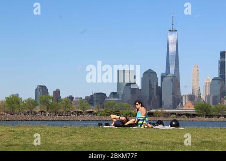 3 mai 2020, Jersey City, New Jersey, États-Unis: Ce couple ne porte pas de masque installé au Liberty State Park le long de la rivière Hudson à Jersey City, en face du World Trade Center. C'est l'un des sites extérieurs avec les clubs de golf du New Jersey rouverts au cours du week-end malgré une semaine sombre qui a vu le nombre de morts quotidiennes dépasser le péage de l'État de New York avant de descendre. ''la réouverture est un test énorme, '' a prévenu Gov. Phil Murphy disant que « si les choses vont mal », il peut fermer à nouveau les parcs et les terrains de golf. Les visiteurs doivent adhérer à l'éloignement social et les revêtements de visage sont fortement encouragés. L'état Banque D'Images