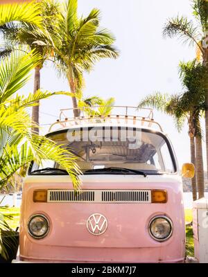 Un campervan rose VW garé à côté des palmiers Banque D'Images