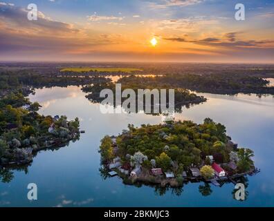 Budapest, Hongrie - vue aérienne de la petite île de pêche sur le lac Kavicsos (Kavicsos to) du district de Csepel avec un lever de soleil chaud et des nuages réfléchissants. T Banque D'Images