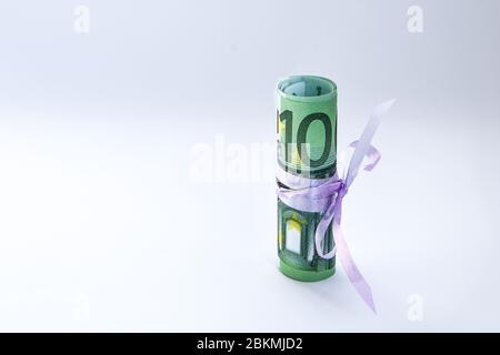 Cadeau de 100 euros, rouleau d'argent européen, billet de banque en euros laminé avec un noeud en ruban rose Banque D'Images