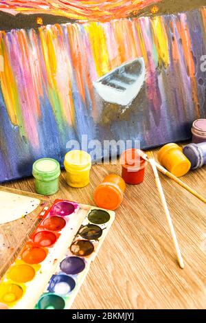La tempera peint sur la table dans un atelier, la mise au point sélective, le jeu de peintures aquarelles, les brosses pour la peinture et la palette Banque D'Images