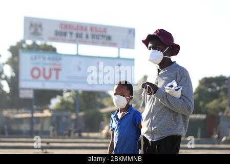 Harare, Zimbabwe. 4 mai 2020. Deux enfants portant des masques de visage marchent dans une rue à Harare, au Zimbabwe, le 4 mai 2020. Le président zimbabwéen Emmerson Mnangagwa a prolongé le 1er mai un verrouillage visant à freiner la propagation de la COVID-19 de deux semaines supplémentaires au 17 mai. La police du Zimbabwe va arrêter quiconque quitte son domicile sans porter de masques à visage à partir de lundi. Crédit: Shaun Jusa/Xinhua/Alay Live News Banque D'Images