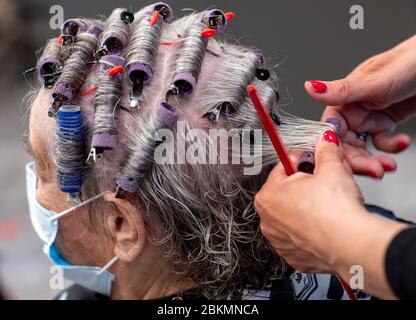 Greifswald, Allemagne. 04 mai 2020. Yvonne Gossau fait les cheveux de sa cliente Gerda Papke dans le salon HARRgenau avec un masque facial. A partir du 04.05.2020, les coiffeurs fermés en raison de mesures de protection de la couronne seront autorisés à rouvrir leurs magasins. Dans les salons, comme dans le commerce de détail, les masques sont également obligatoires. Crédit: Jens Büttner/dpa-Zentralbild/ZB/dpa/Alay Live News Banque D'Images