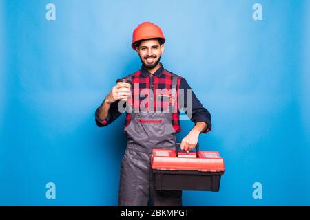 Portrait de l'homme heureux indien tenant une boîte à outils rouge isolée sur fond bleu Banque D'Images