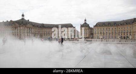 Bordeaux, Aquitaine / France - 06 10 2018 : Femme fille joue en fontaine miroir devant la place de la Bourse à Bordeaux, France Banque D'Images