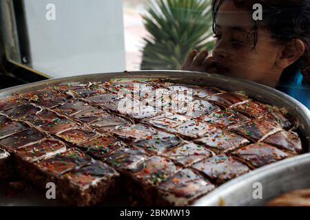 Sanaa, Yémen. 4 mai 2020. Une fille regarde les bonbons traditionnels du Ramadan en vente dans une boutique à Sanaa, Yémen, 4 mai 2020. Crédit: Mohammed Mohammed/Xinhua/Alay Live News Banque D'Images