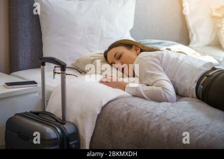 Une femme d'affaires fatiguée dore dans la chambre de l'hôtel. Banque D'Images