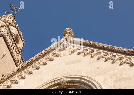 Détail de la maçonnerie de l'église St Marc à la ville de Korcula, Dalmatie, Croatie. Les beaux éléments gothiques et un ciel bleu sur un soleil Banque D'Images
