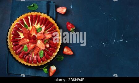 Vue de dessus de flan fraisier frais sur fond bleu foncé Banque D'Images