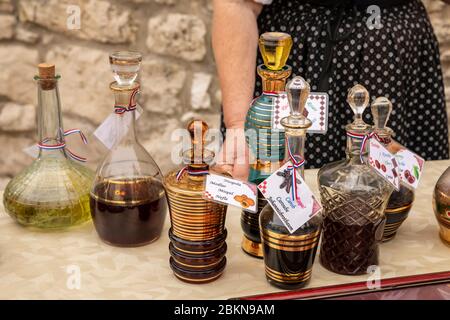 Collection de catafes traditionnelles peintes en or de verre remplies de fortes liqueurs croates typiques, telles que le mispel, le caroub, la cerise, le myrte et la rose à b. Banque D'Images