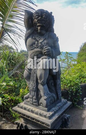 Gros plan de la statue en pierre du Temple Batu Bolong près de Tanah Lot à Bali, Indonésie. Une statue sculptée aux détails fins qui se tient devant l'entrée Banque D'Images