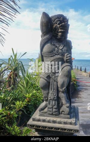 Gros plan de la statue en pierre du Temple Batu Bolong près de Tanah Lot à Bali, Indonésie. Une statue sculptée aux détails fins qui se tient devant l'entrée Banque D'Images