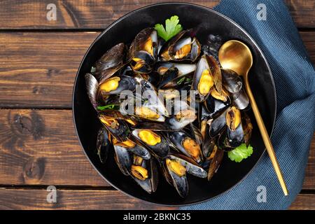 Vue de dessus de l'assiette avec des moules fraîchement cuites sur fond rustique foncé Banque D'Images