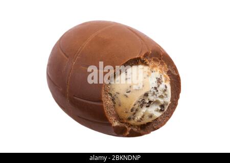Oreo Easter Egg déballé et commencé à montrer le contenu isolé sur fond blanc - oeuf de chocolat au lait avec une crème de remplissage de lait et des morceaux de biscuits Banque D'Images