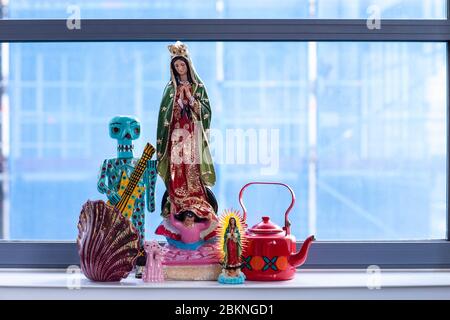 Un détail d'une collection de statues colorées a établi un intérieur de loft de ville. Une maison bohème, moderne, mélange et s'assortir éclectique style maison avec notre dame guadalupe Banque D'Images