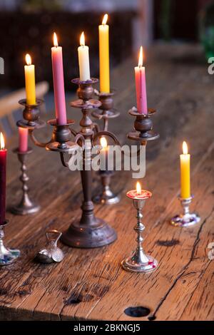 Bougies de différentes couleurs dans un support de bougie en métal vintage brûlant pour créer une atmosphère agréable dans un environnement de maison. Un style éclectique de vie avec Banque D'Images