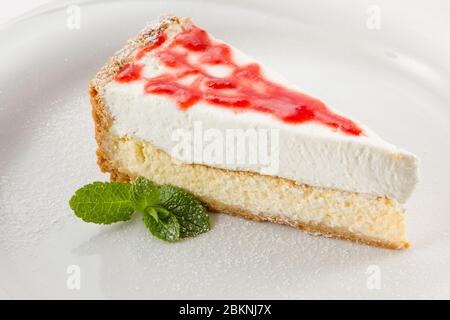 cheesecake aux baies et à la menthe arrosé de sucre en poudre sur une assiette Banque D'Images